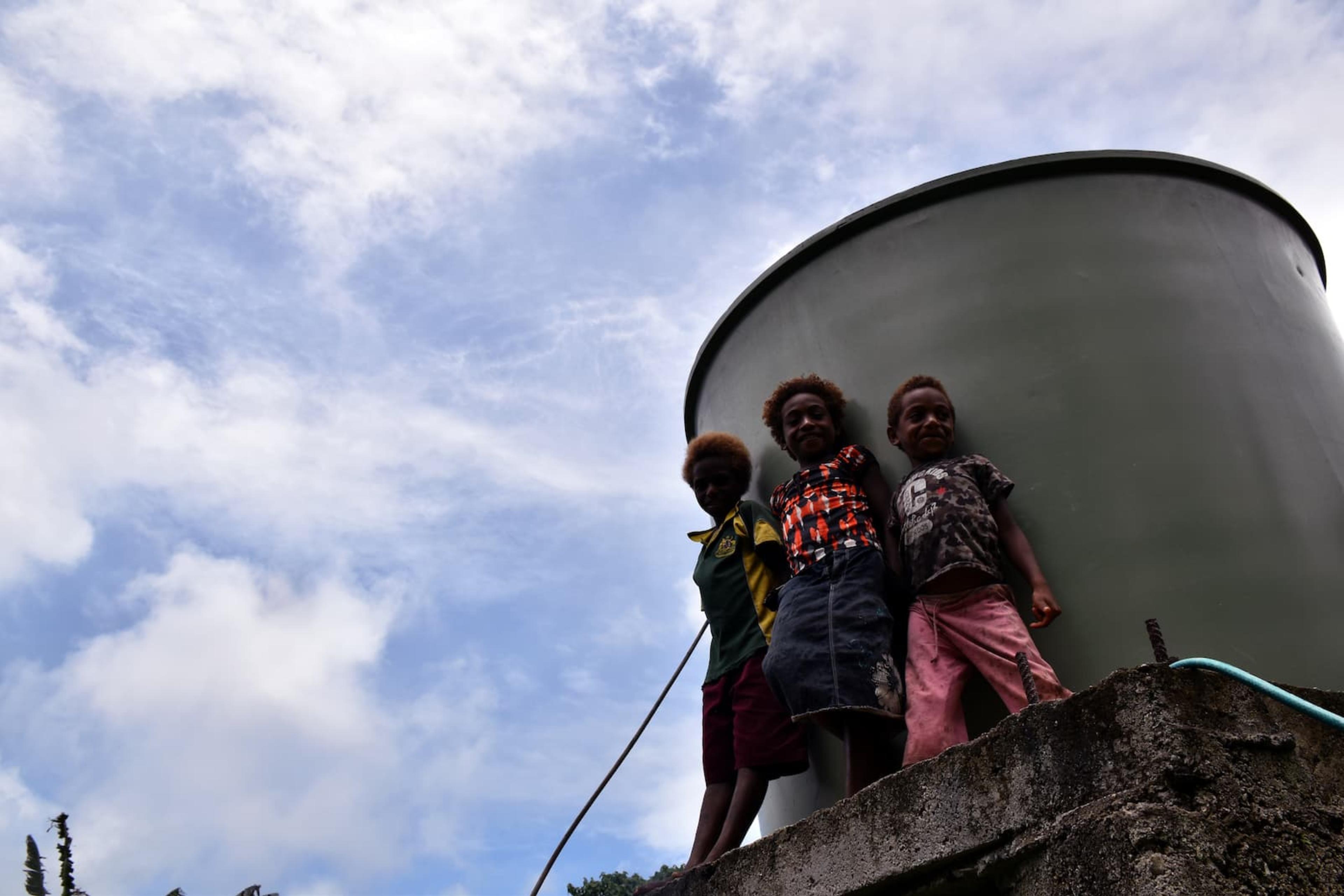 Pacific children Gladwin, Nalam and Mark stand atop the water tower in Vanuatu
