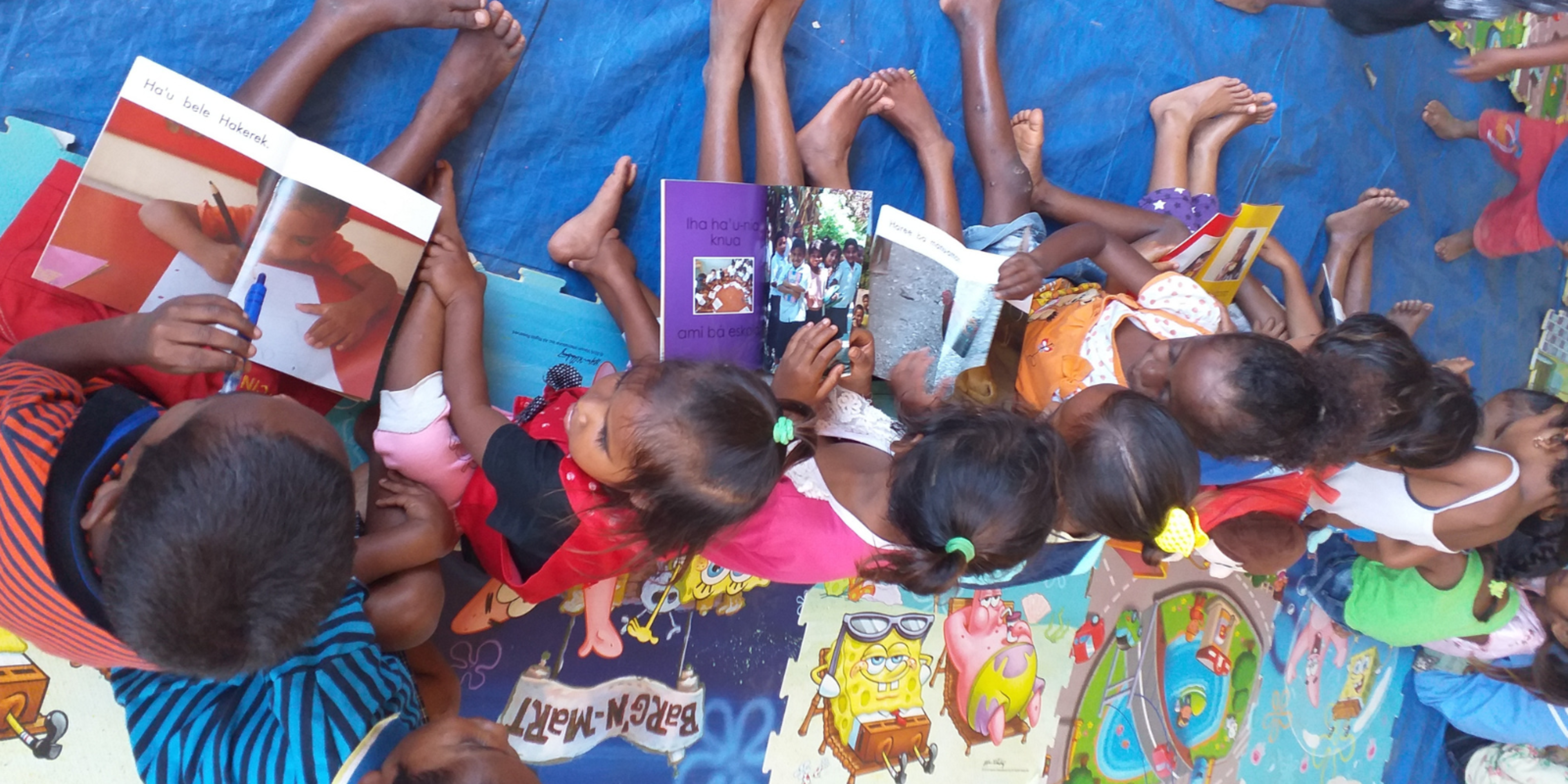 Children are excited to read a book in Tetun (one of Timor-Leste's national languages