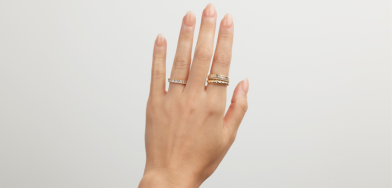 hand with multiple gold and diamond bands