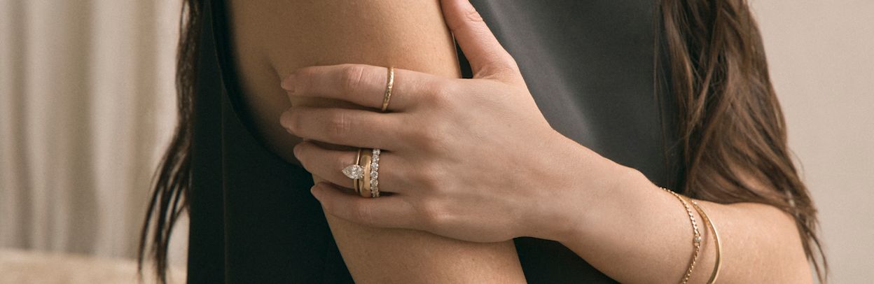 woman wearing prong set engagement ring and eternity band