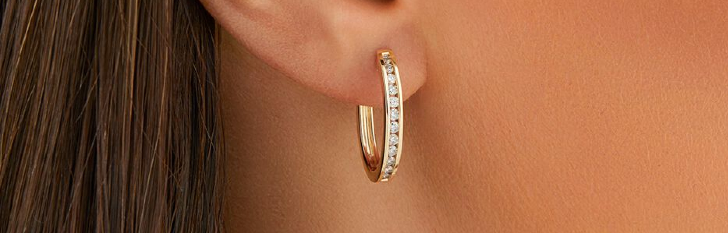 gold huggie hoop earrings with diamonds in ear