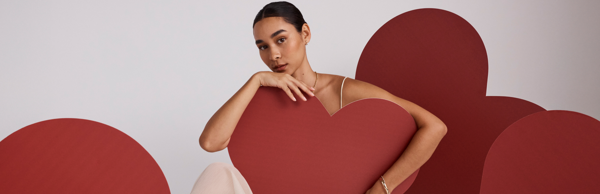 Model posing with oversized cardboard cutout love hearts