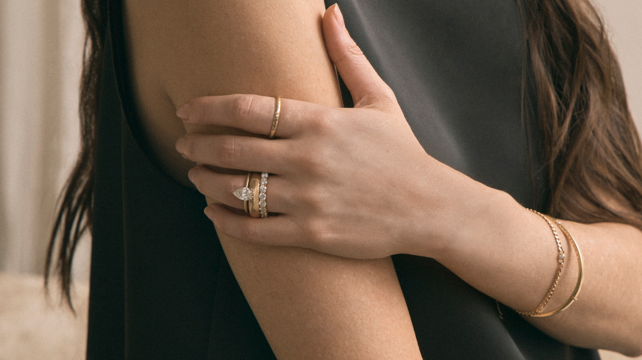 woman wearing prong set engagement ring and eternity band