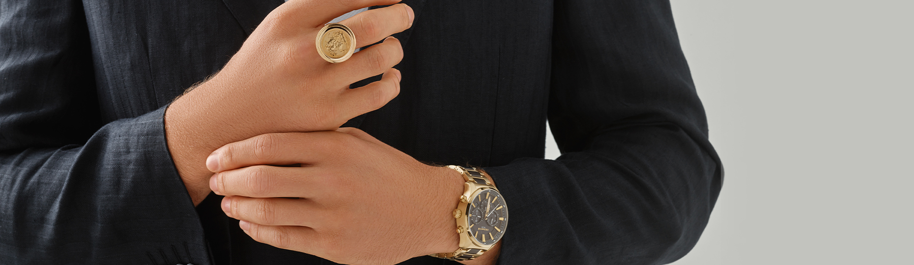 man wearing large gold coin sovereign ring and gold watch