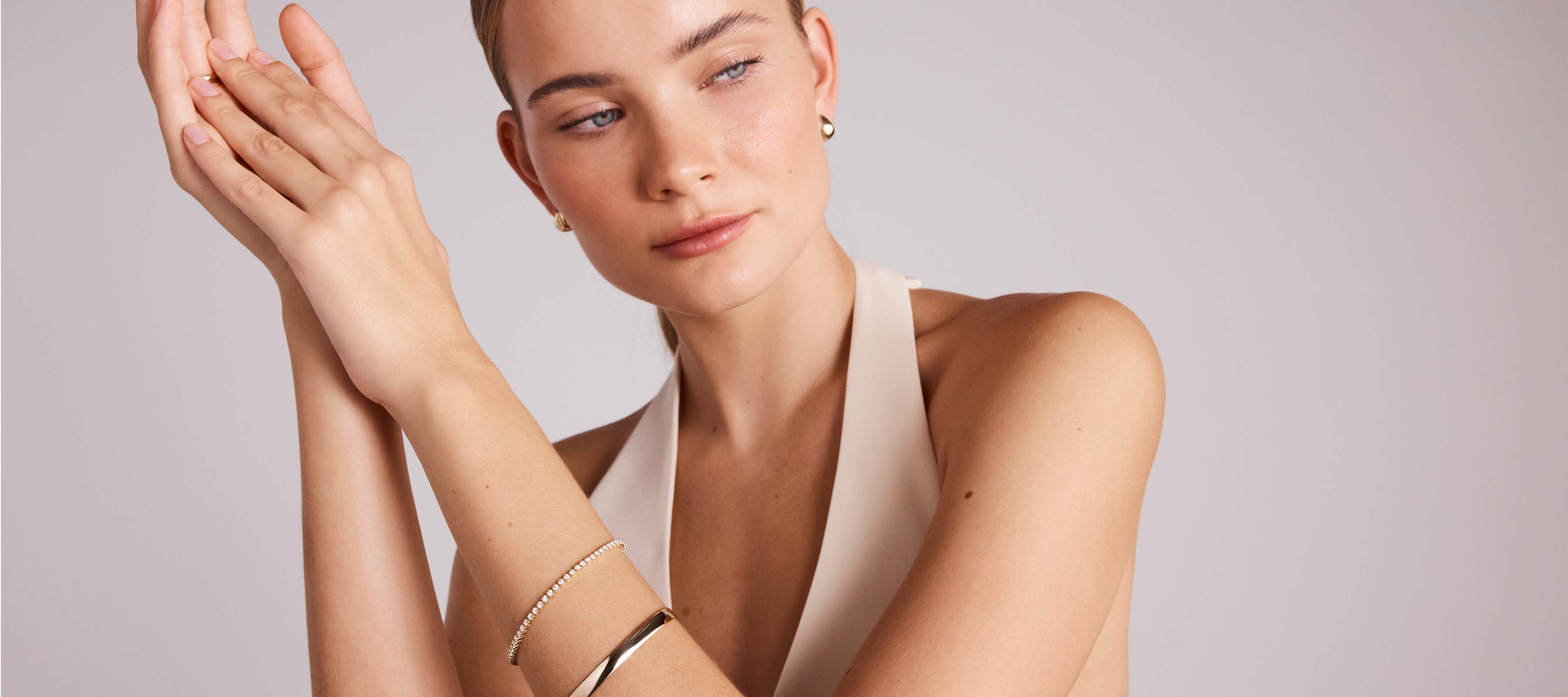girl wearing a diamond tennis bracelet and gold bangle