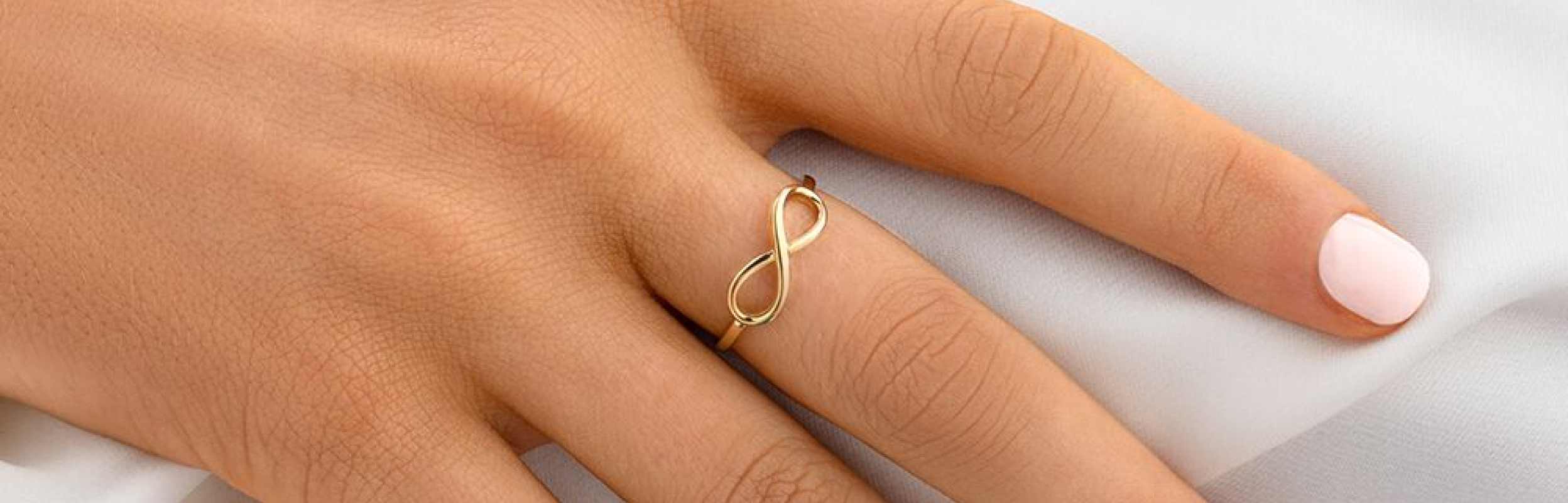 gold infinity ring worn by woman