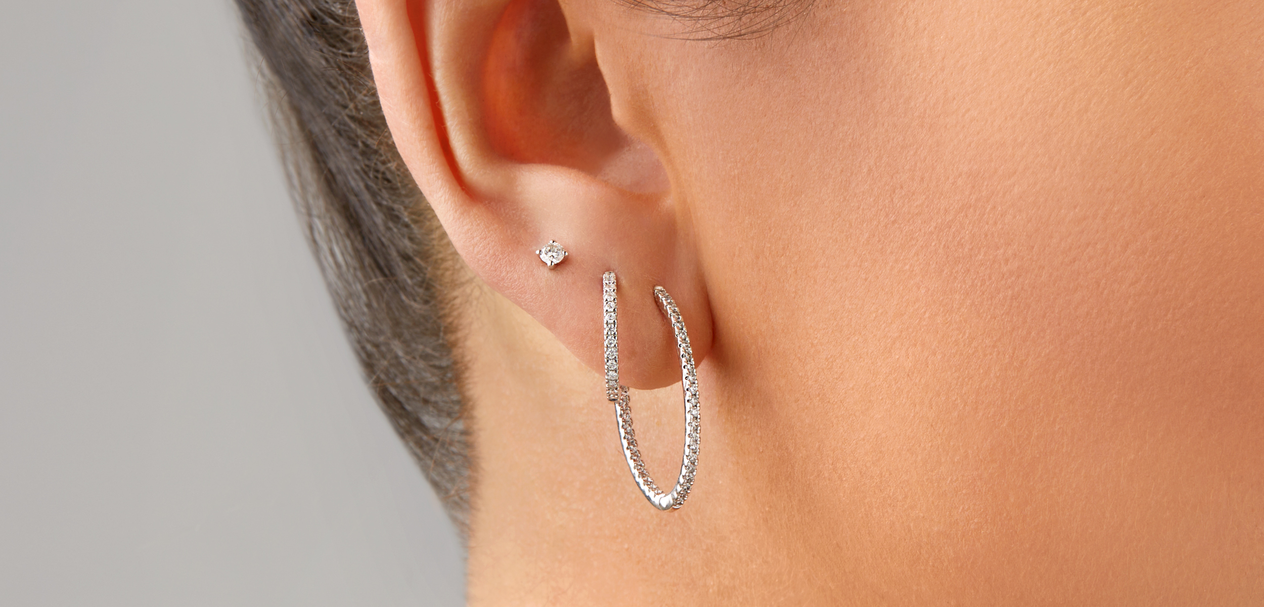 Close up of two diamond hoops and a diamond stud stacked together