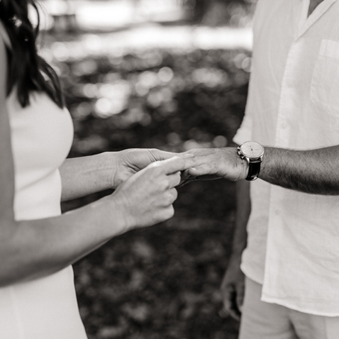 Couple putting on wedding bands 