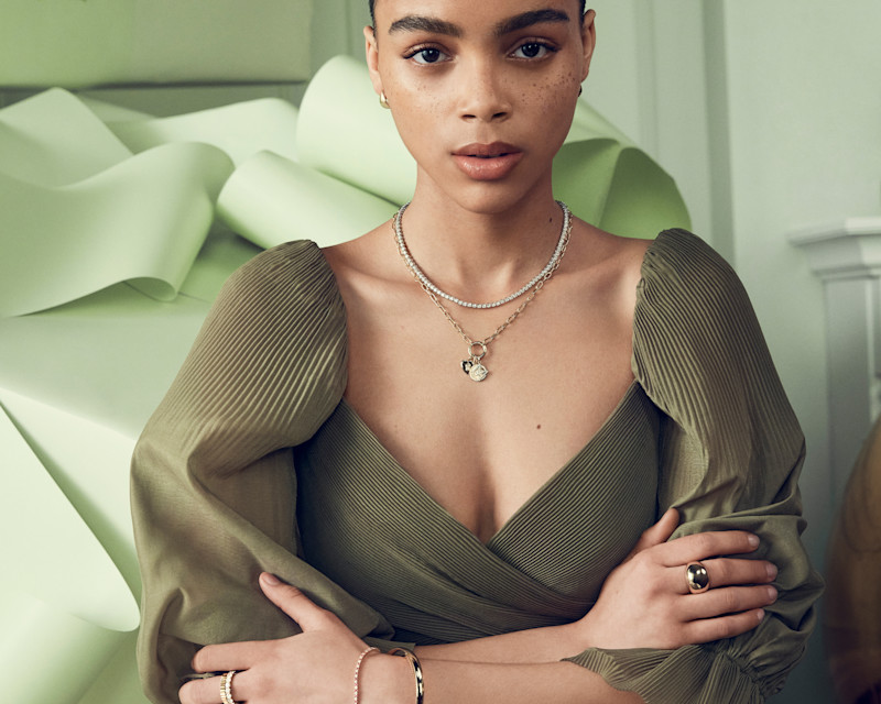 women in green blouse wearing gold bangles, and gold necklaces