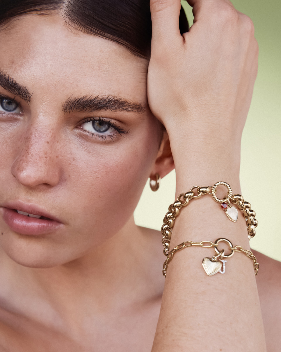 woman wearing chunky charm bracelets with heart pendants