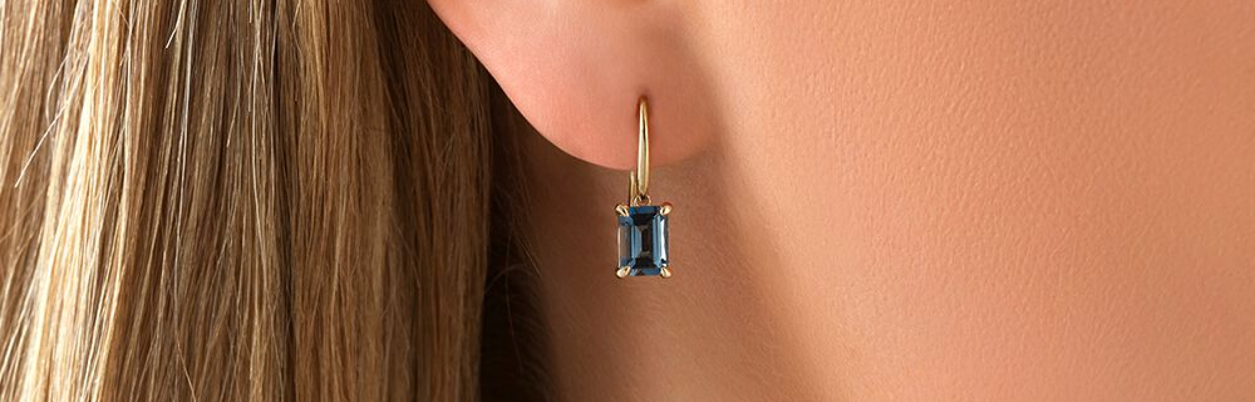 dangling blue stone earring in womans ear
