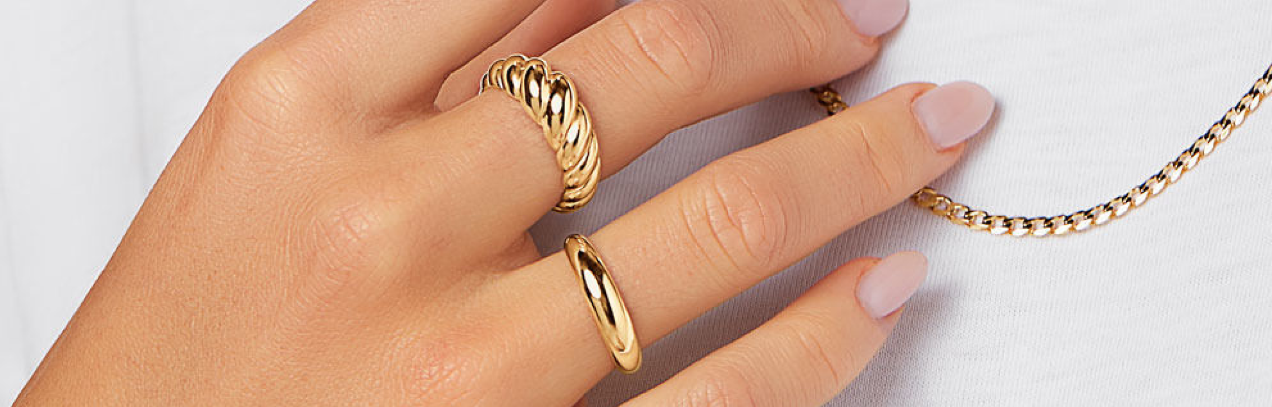 two yellow gold rings on womans hand