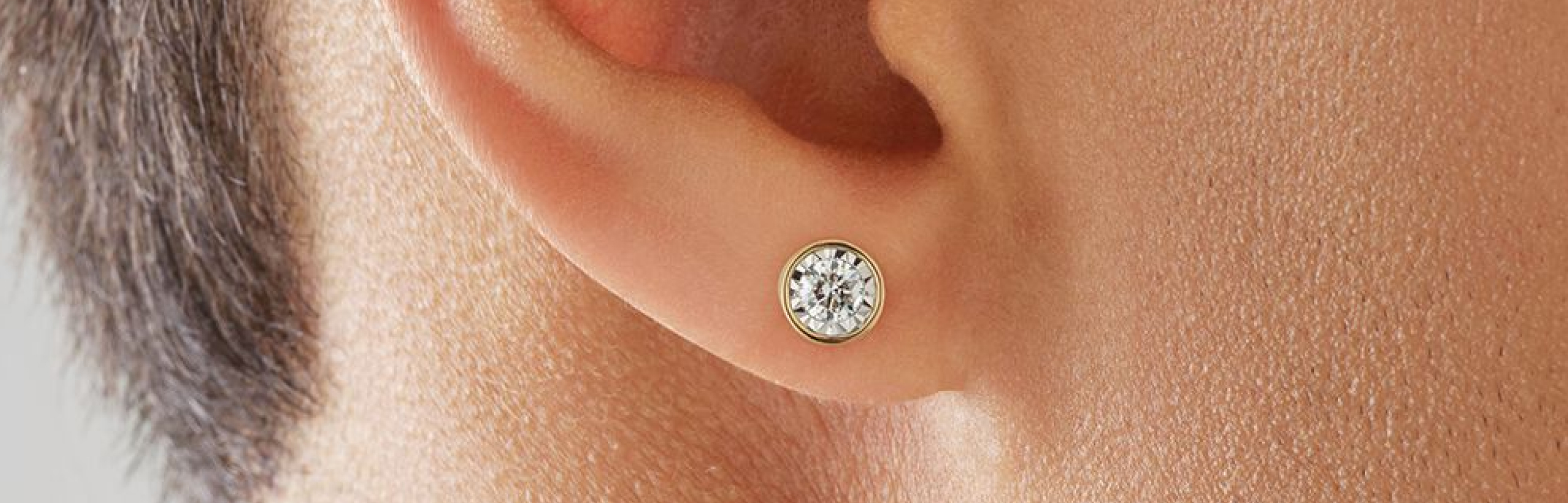 mens gold round diamond stud earring in ear