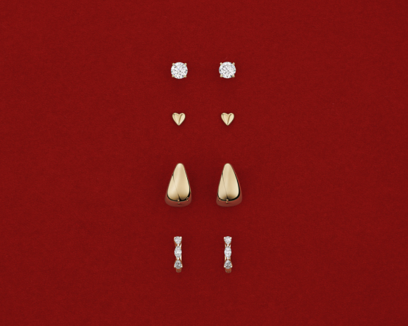 gold and diamond earrings on red background