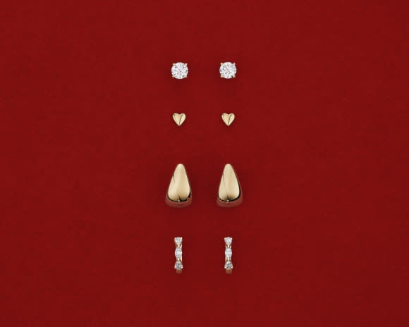 gold and diamond earrings on red background