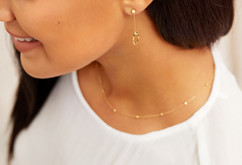 beaded yellow gold chain necklace and yellow gold drop stud earrings.