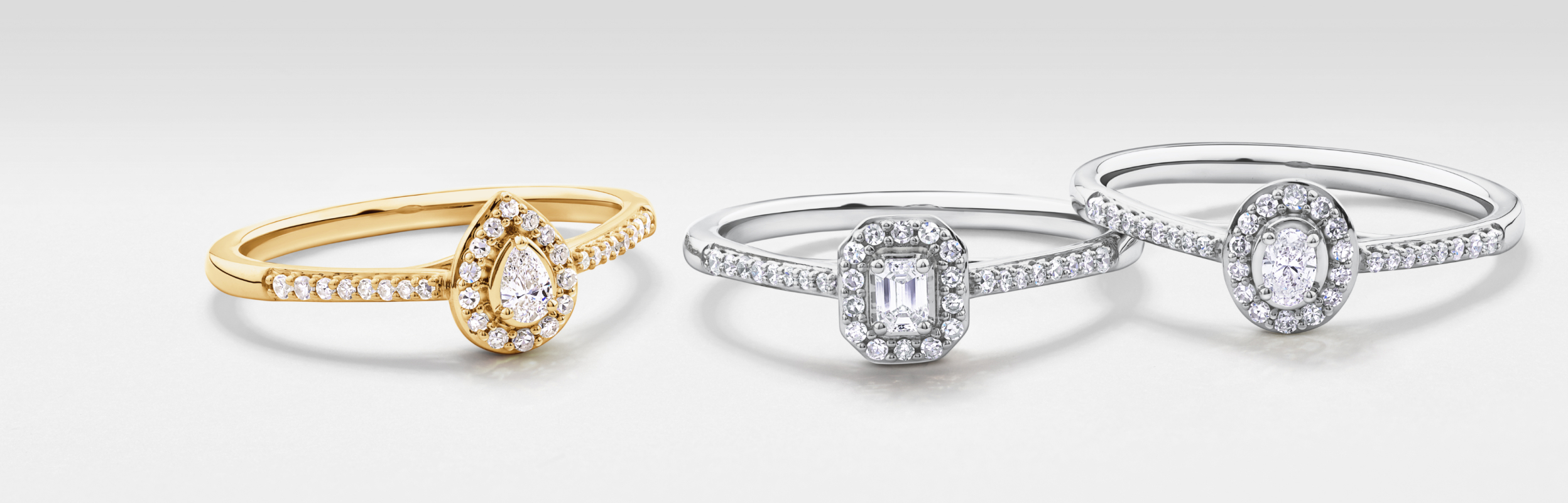three diamond promise rings, one yellow gold and two white gold