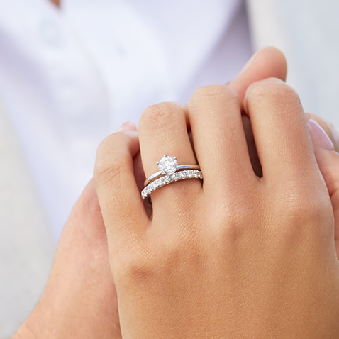 Woman with solitaire engagement ring and diamond wedding band