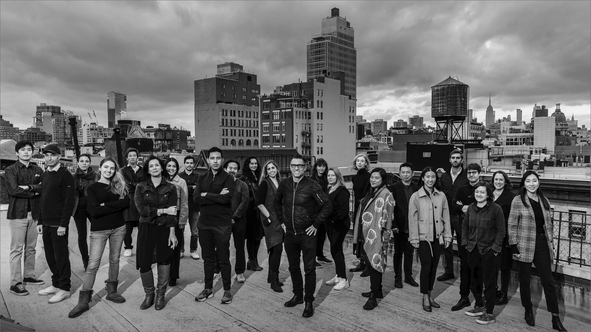 Diverse group of team members stand on a rooftop in NYC