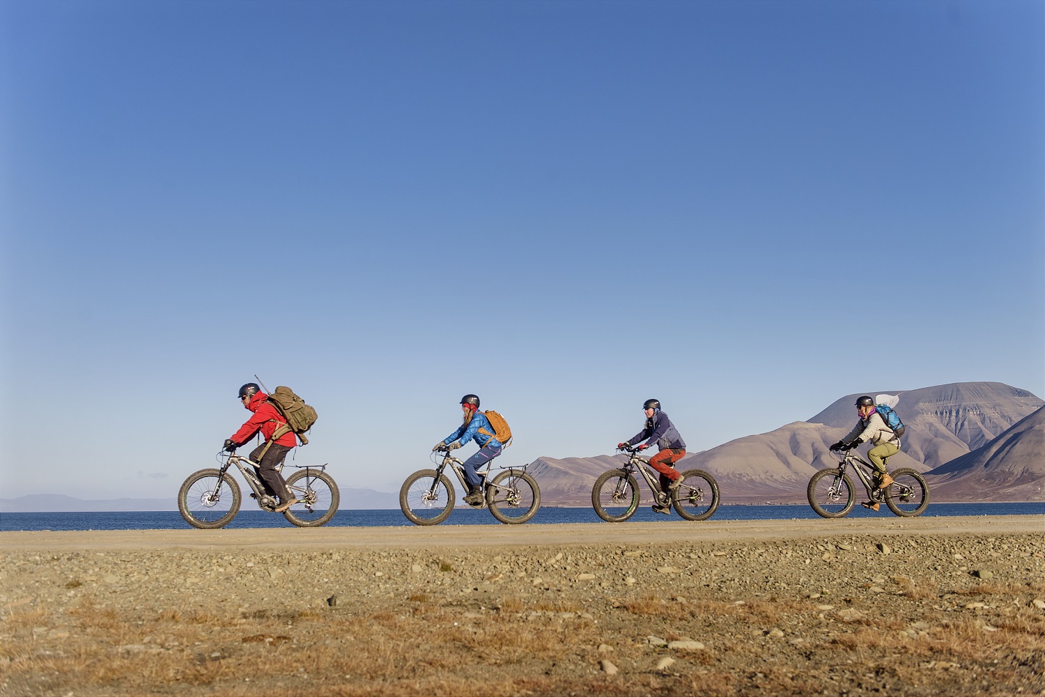 Un groupe de touristes visitant Longyearbyen en bicyclette électrique au Svalbard.