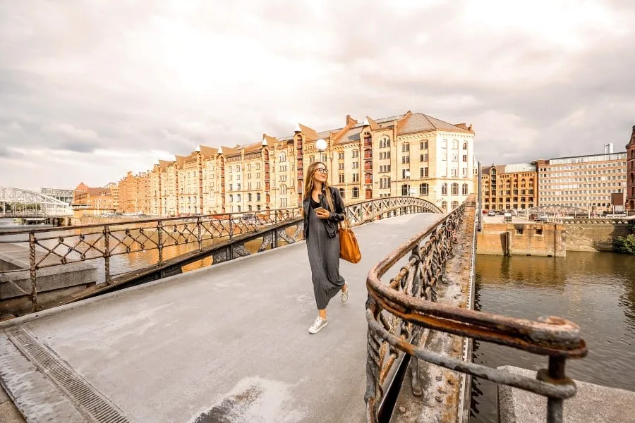 A young woman walks across a bridge in Hamburg, Germany