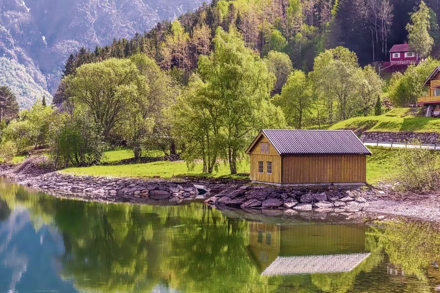 A wooden hut on the shores of Hjørundfjord, Norway