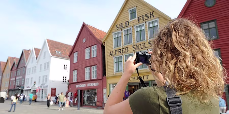 A person standing in front of a building talking on a cell phone