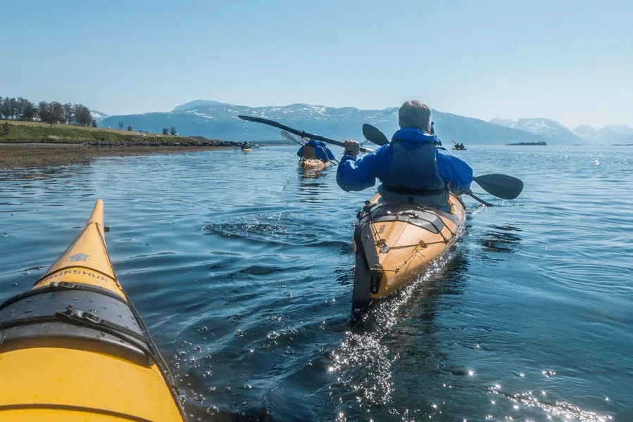 A person riding on the back of a boat in a body of water