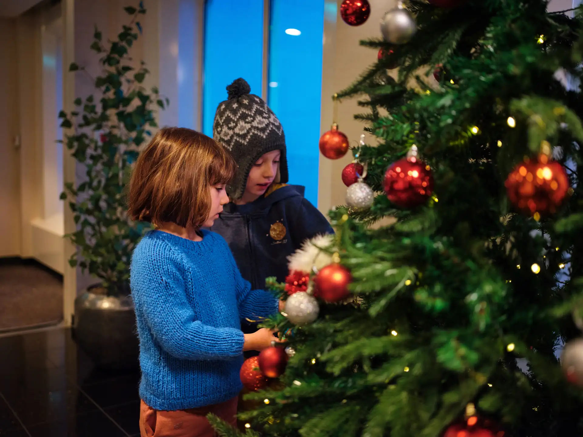 Children decorating a Christmas tree on board Hurtigruten in Norway