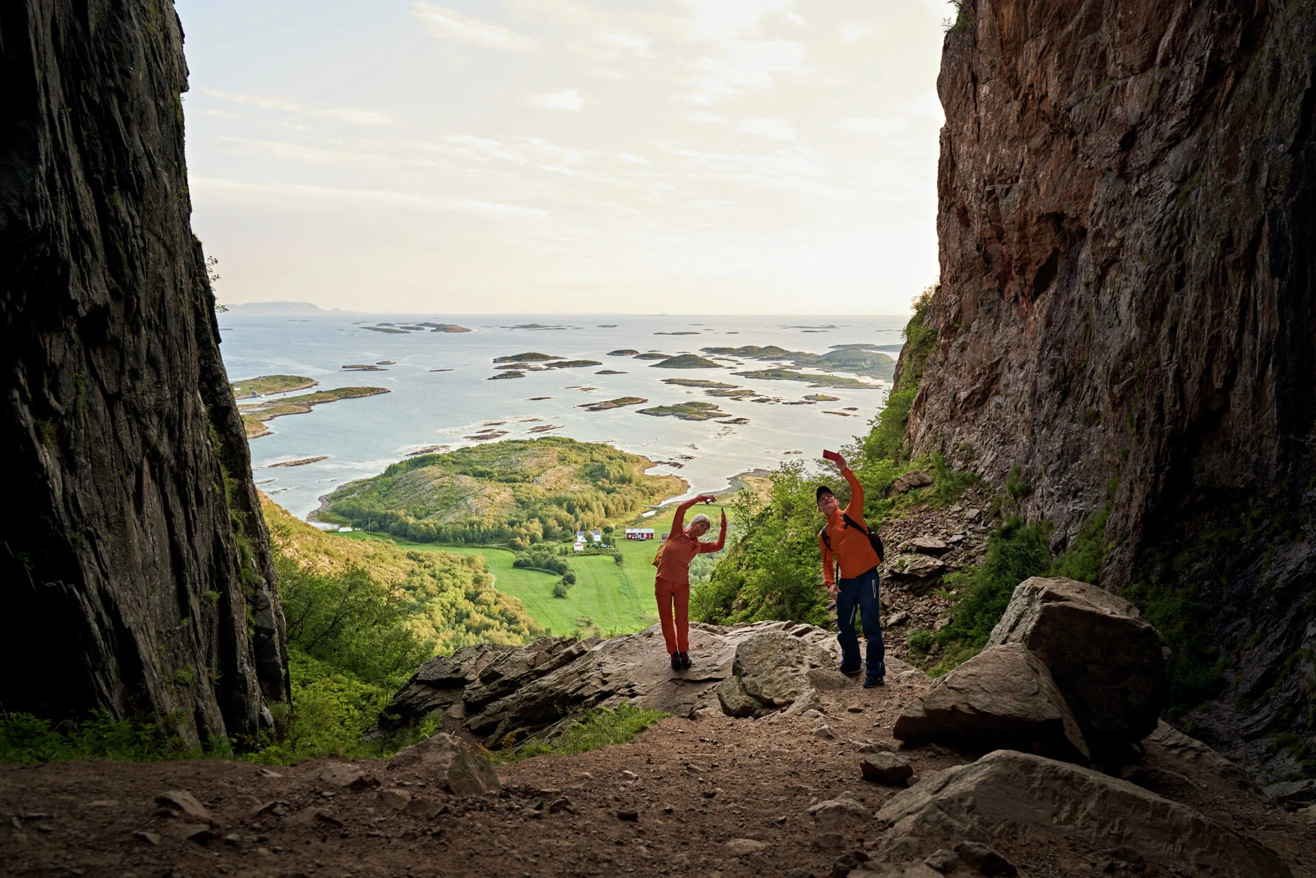 A pair of hikers taking photos at Torghatten mountain