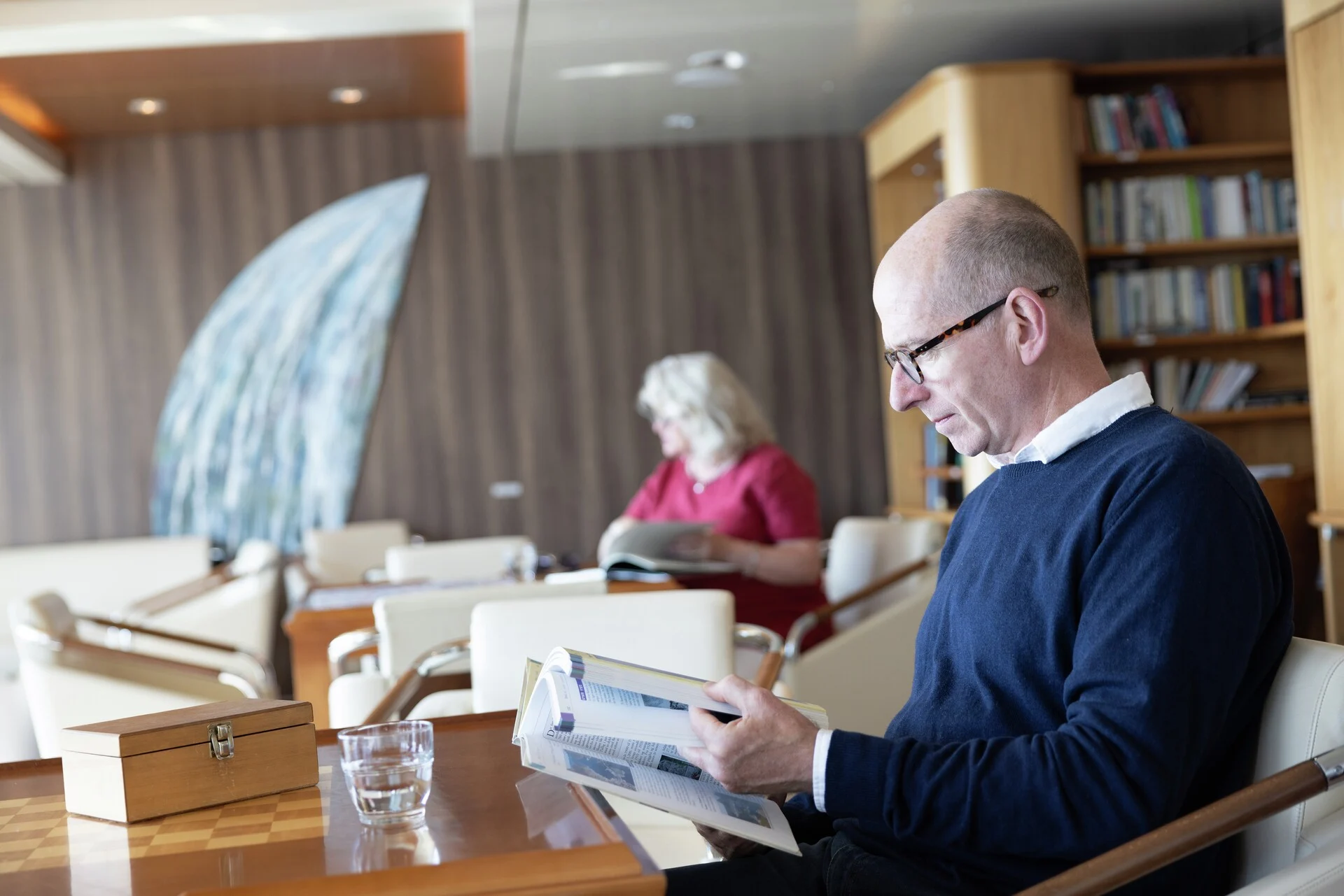 A couple reading in the library of MS Trollfjord