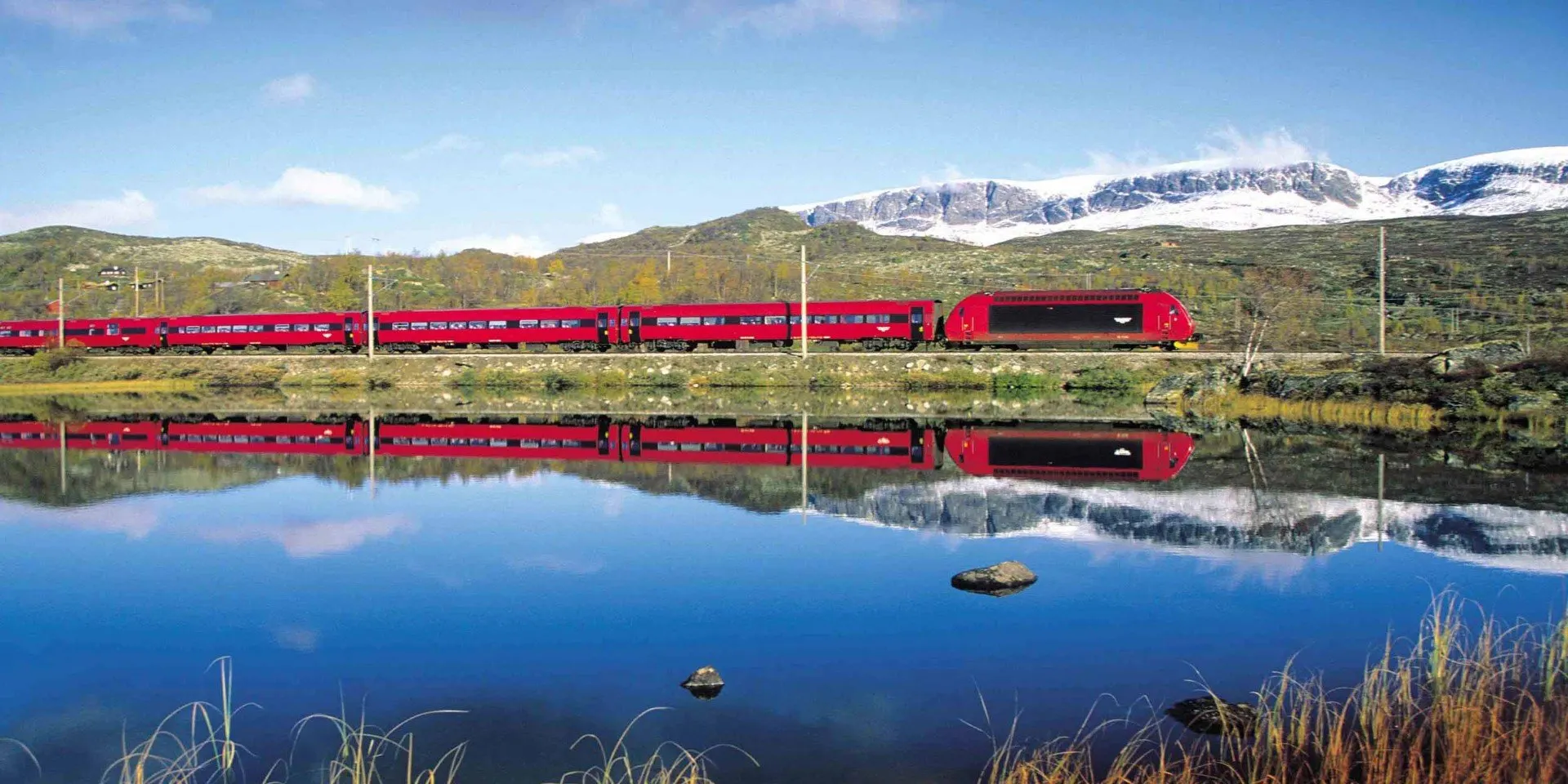 Un train circulant sur des voies ferrées à proximité d'une étendue d'eau