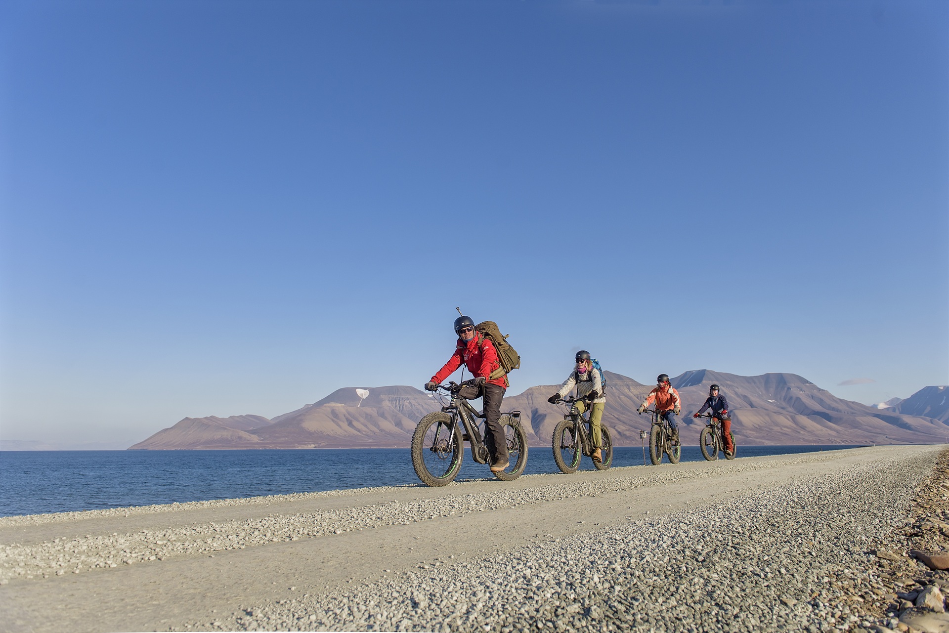 people-riding-electric-bikes-sunny-day-longyearbyen-svalbard-norway-agurtxane-concellon
