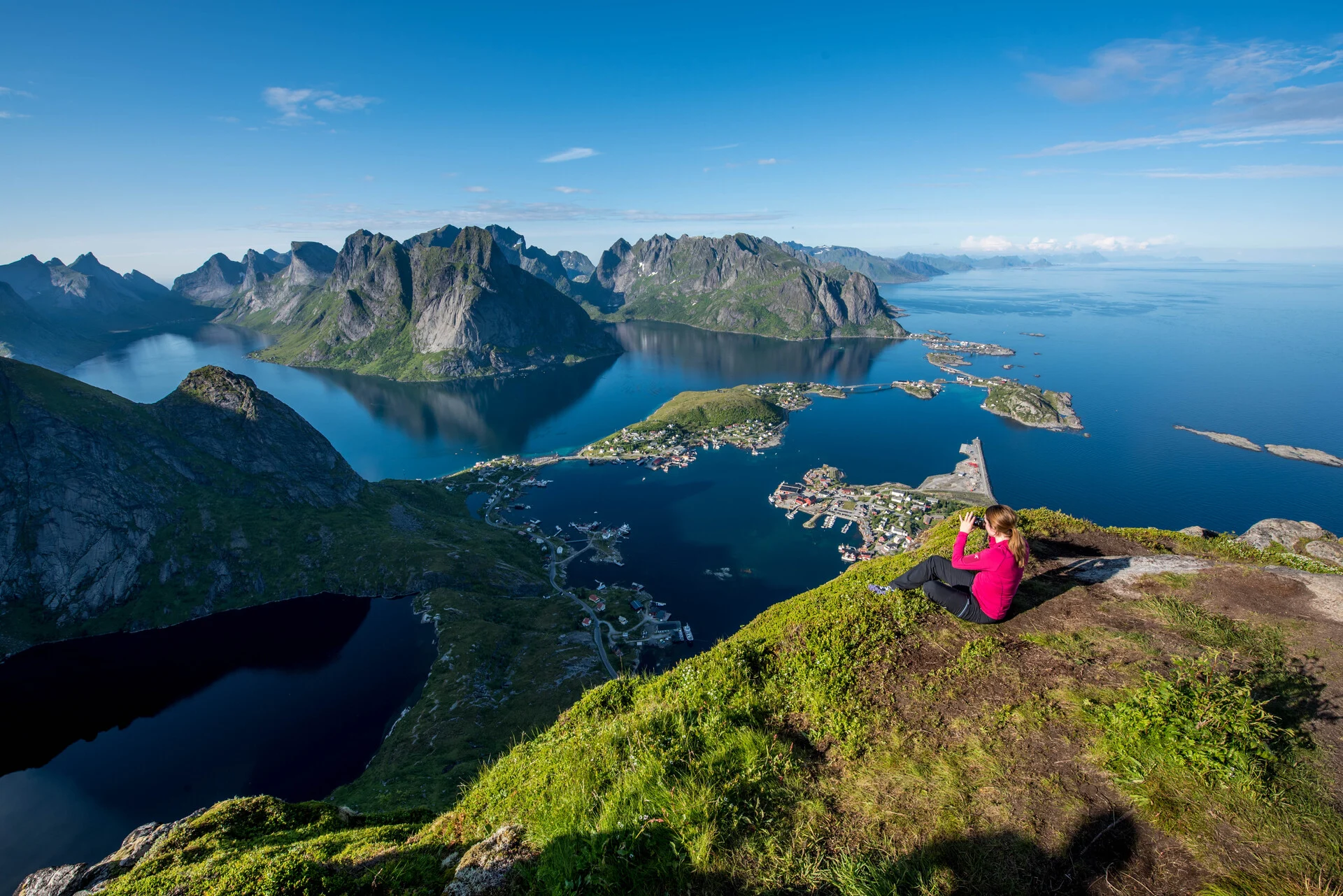 A hiker looking out from the viewpoint of Reinebringen, Reine, Lofoten Islands. Image credit: Tomasz Furmanek - VisitNorway.com