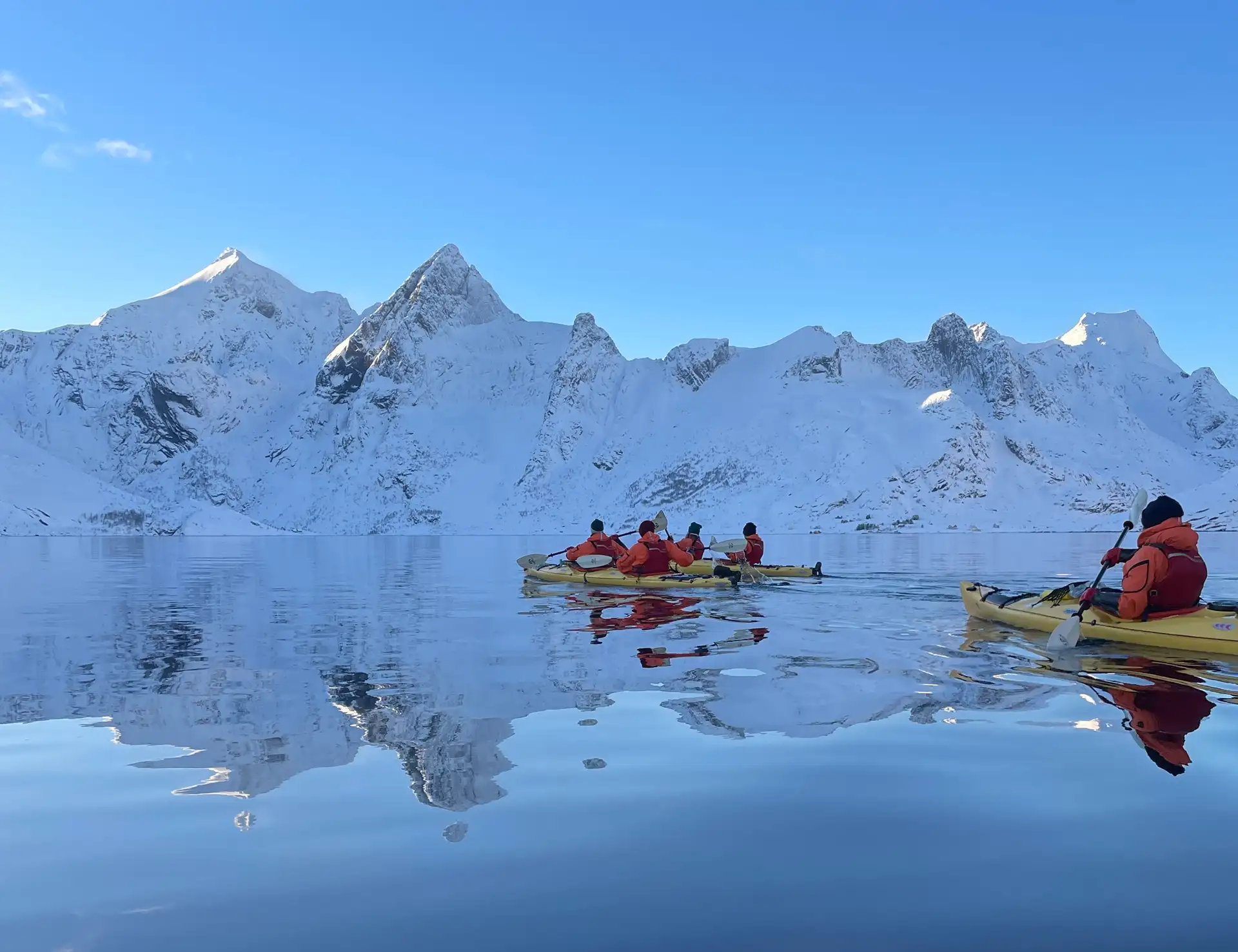 people-yellow-kayaks-snow-fjords-water-reflection