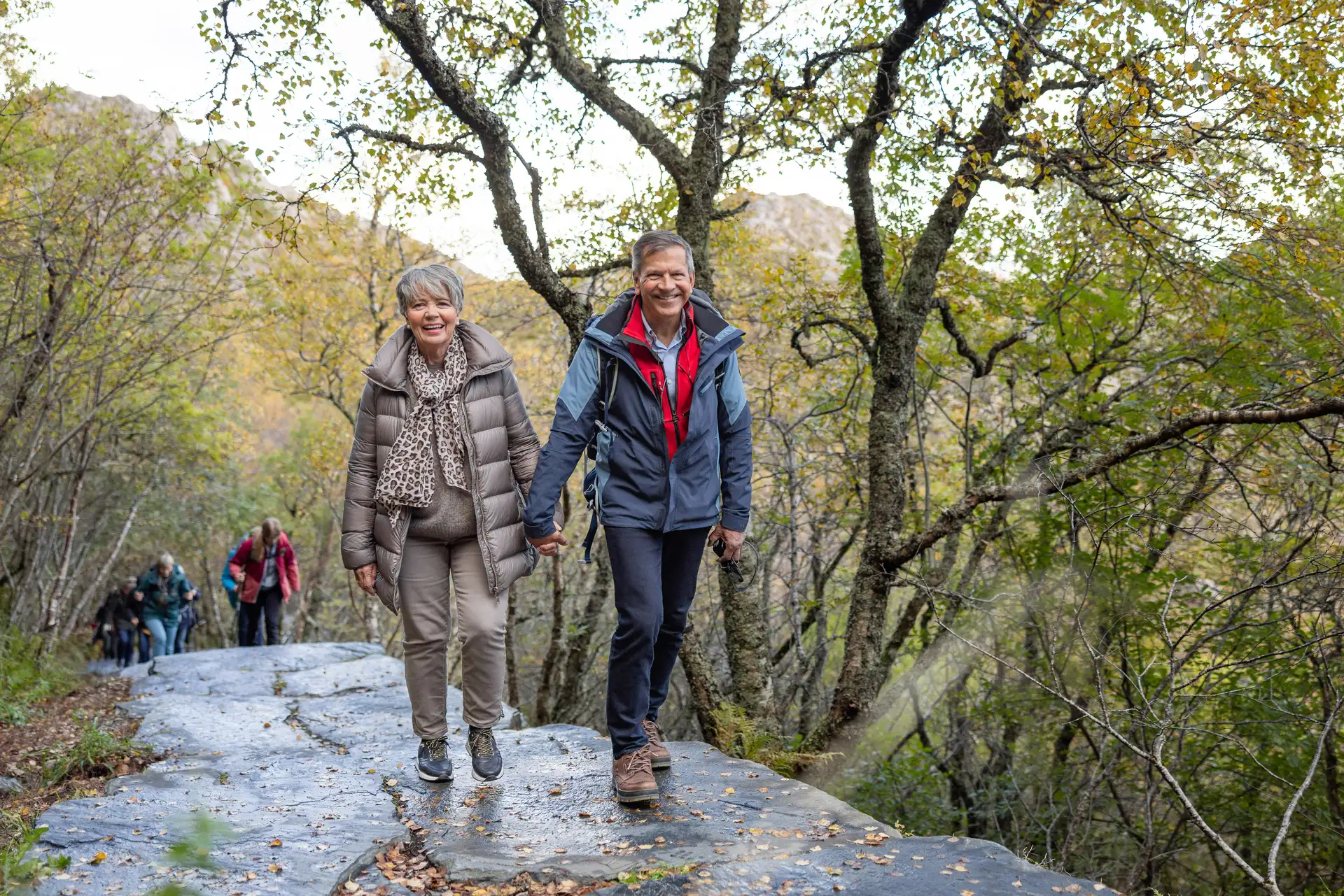 An older couple hiking through Norway in autumn
