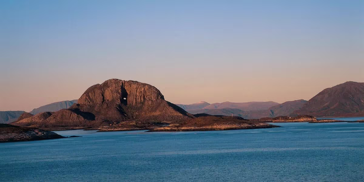 A body of water with a mountain in the background
