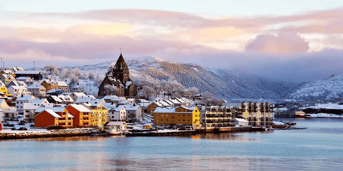 A large ship in a body of water with a mountain in the background