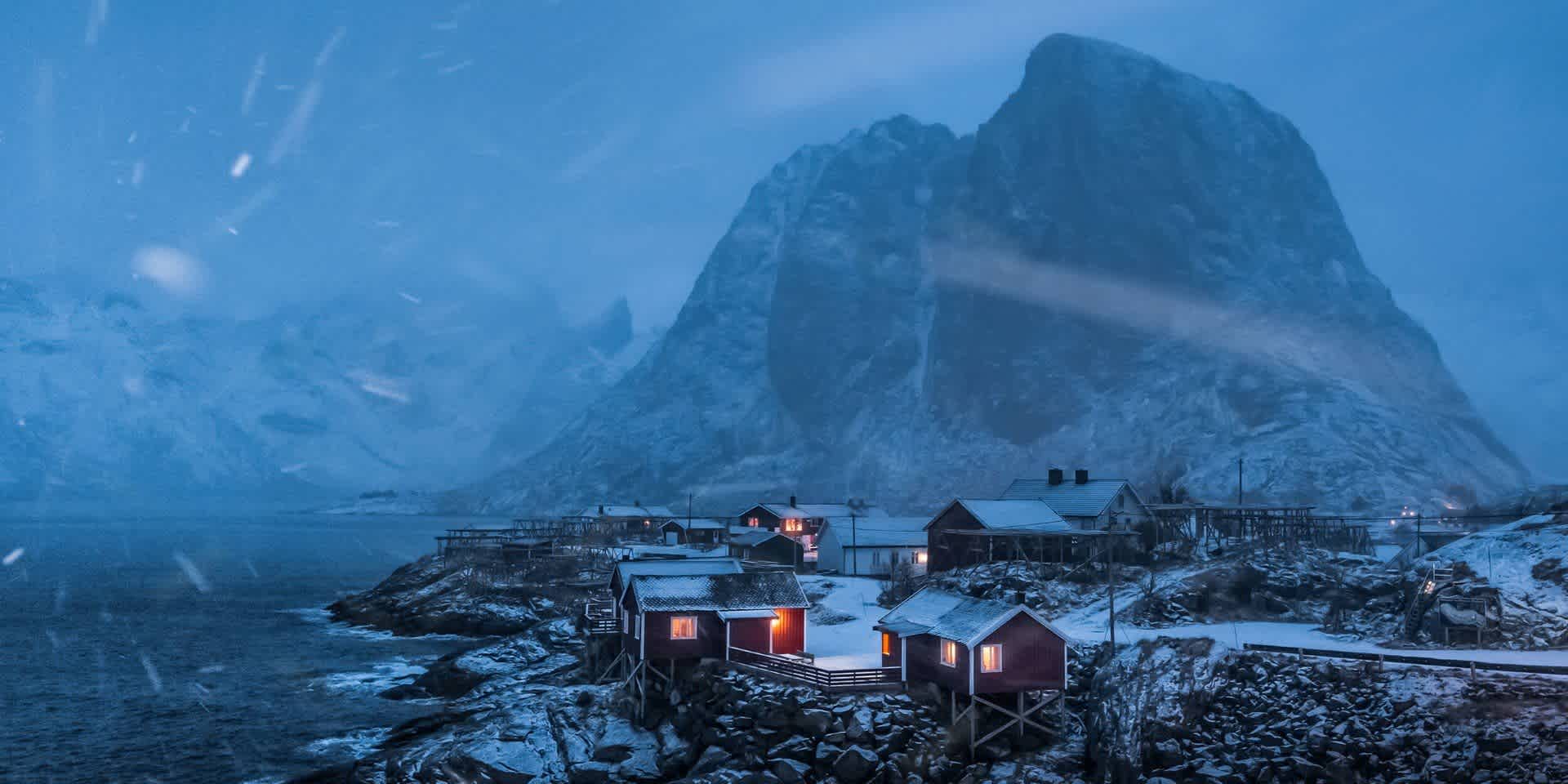 A train is parked on the side of a snow covered mountain