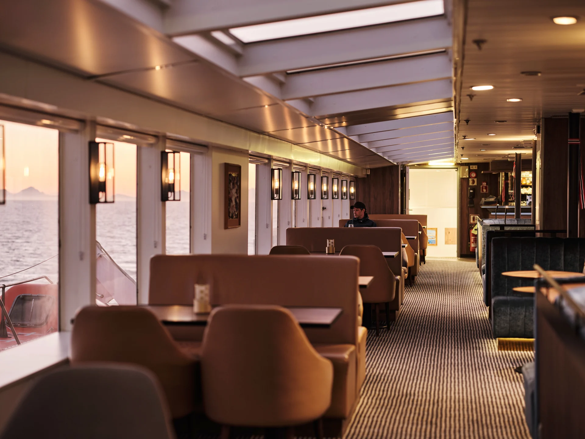 Explorer lounge on MS Vesterålen, with chairs and tables overlooking the sea