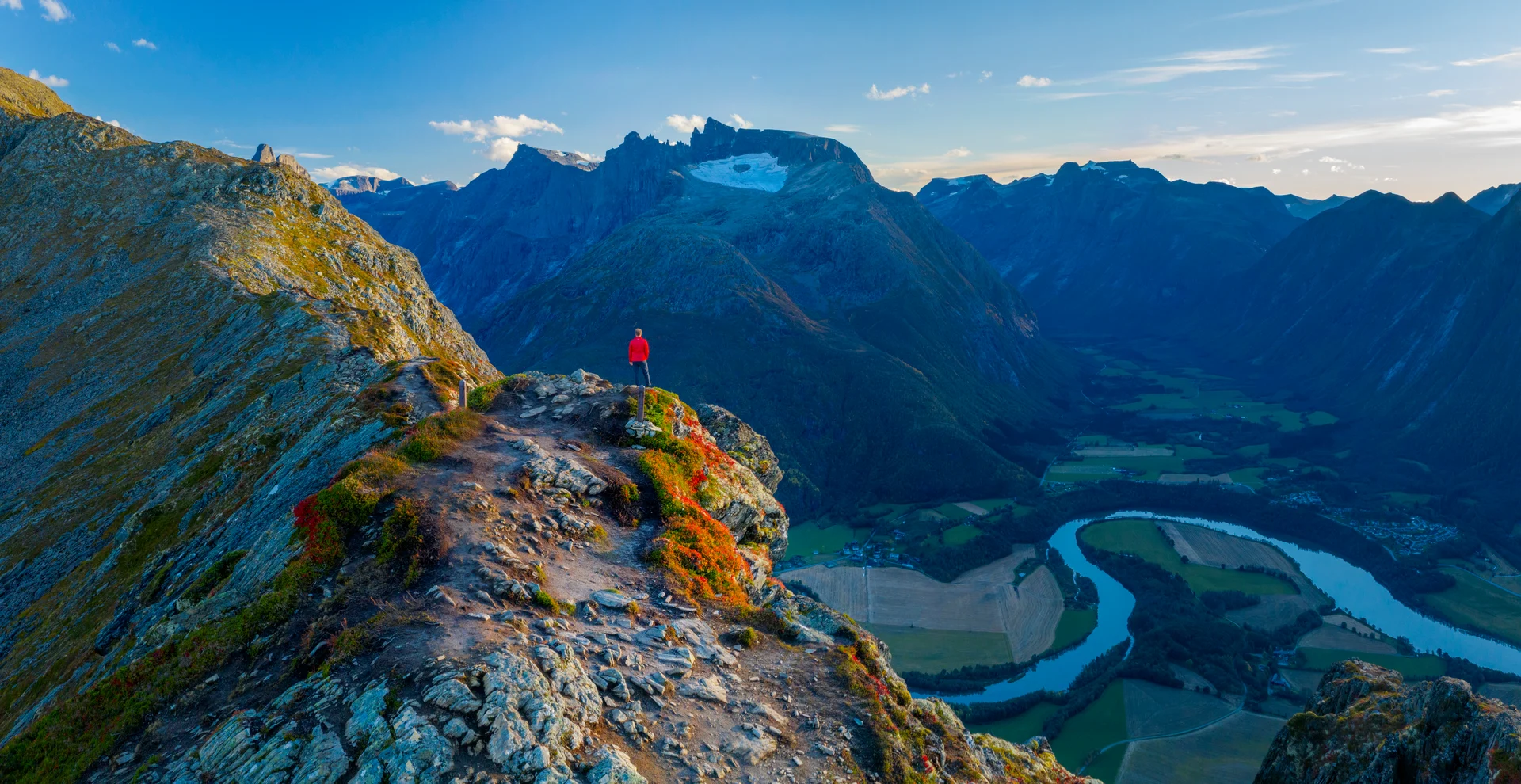 A hiker looking out over the Rauma River from Romsdalseggen, Åndalsnes. Image copyright: Vidar Moløkken - Visit Norway