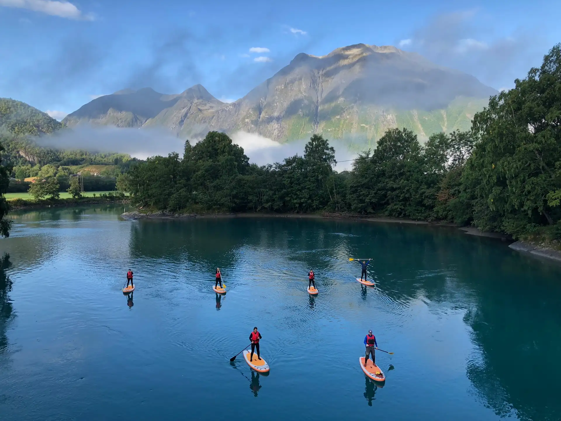 people-paddleboarding-rauma-river-romsdal-alps-andalsnes-norway-daytime-low-clouds