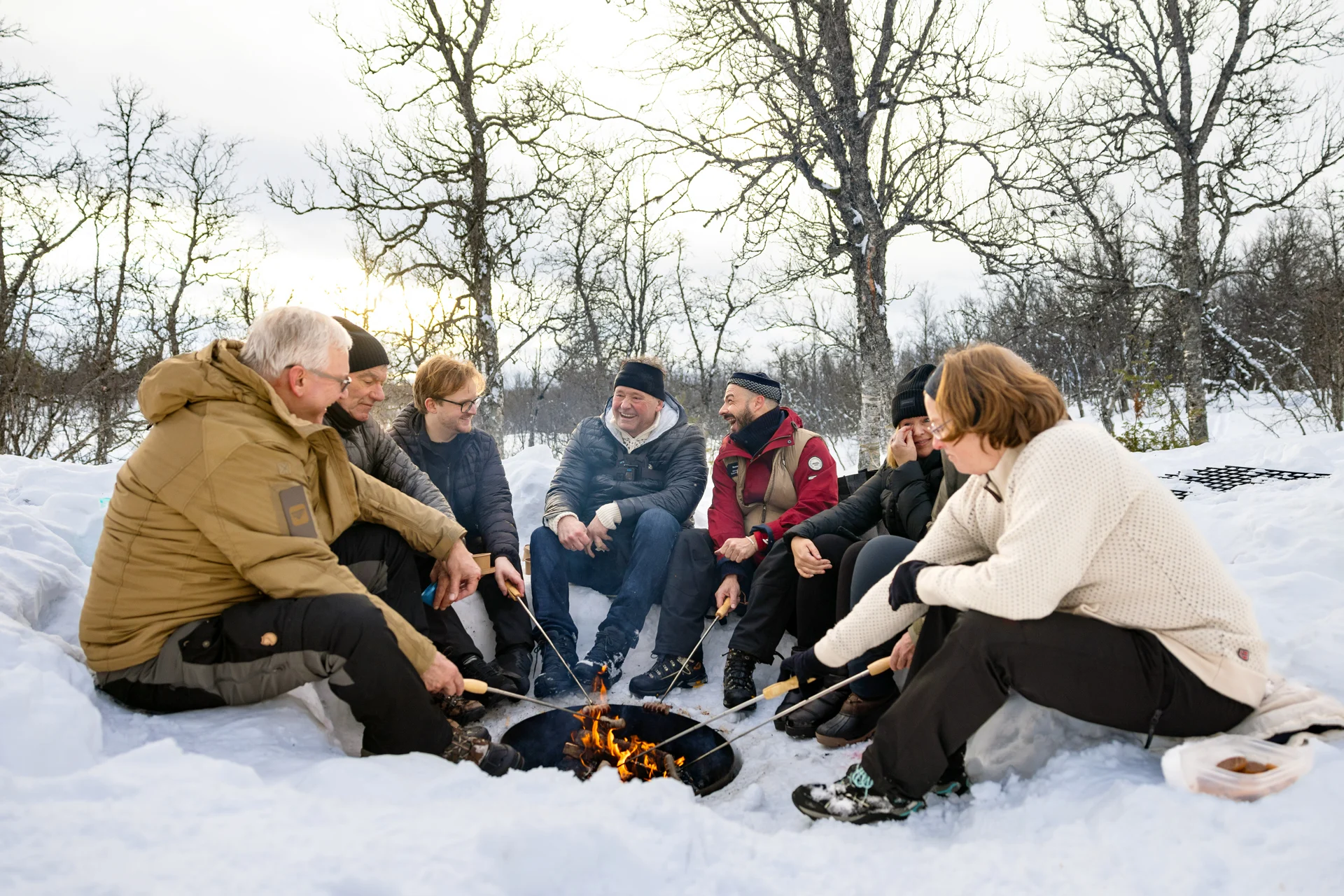 Rösten Sie im Winter Marshmallows am Feuer nach einem Tag mit Schneeschuhen in der Nähe von Tromsø