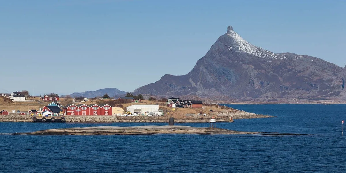 A small boat in a body of water with a mountain in the background