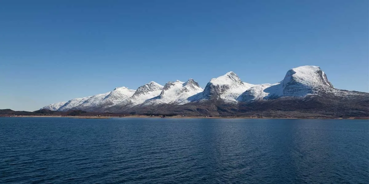 A large body of water with a mountain in the background