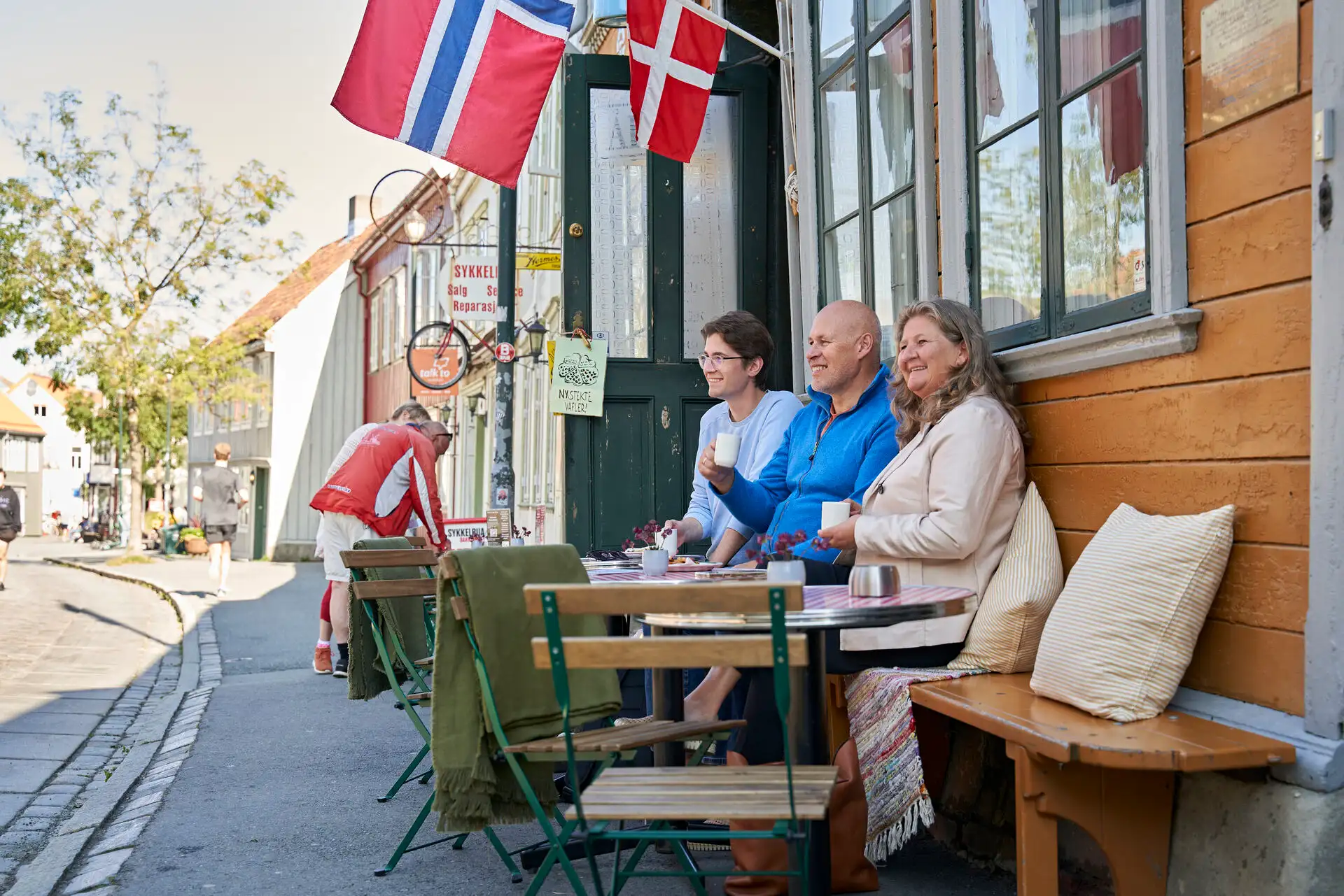 A group sipping coffee outside a cafe in Trondheim, Norway