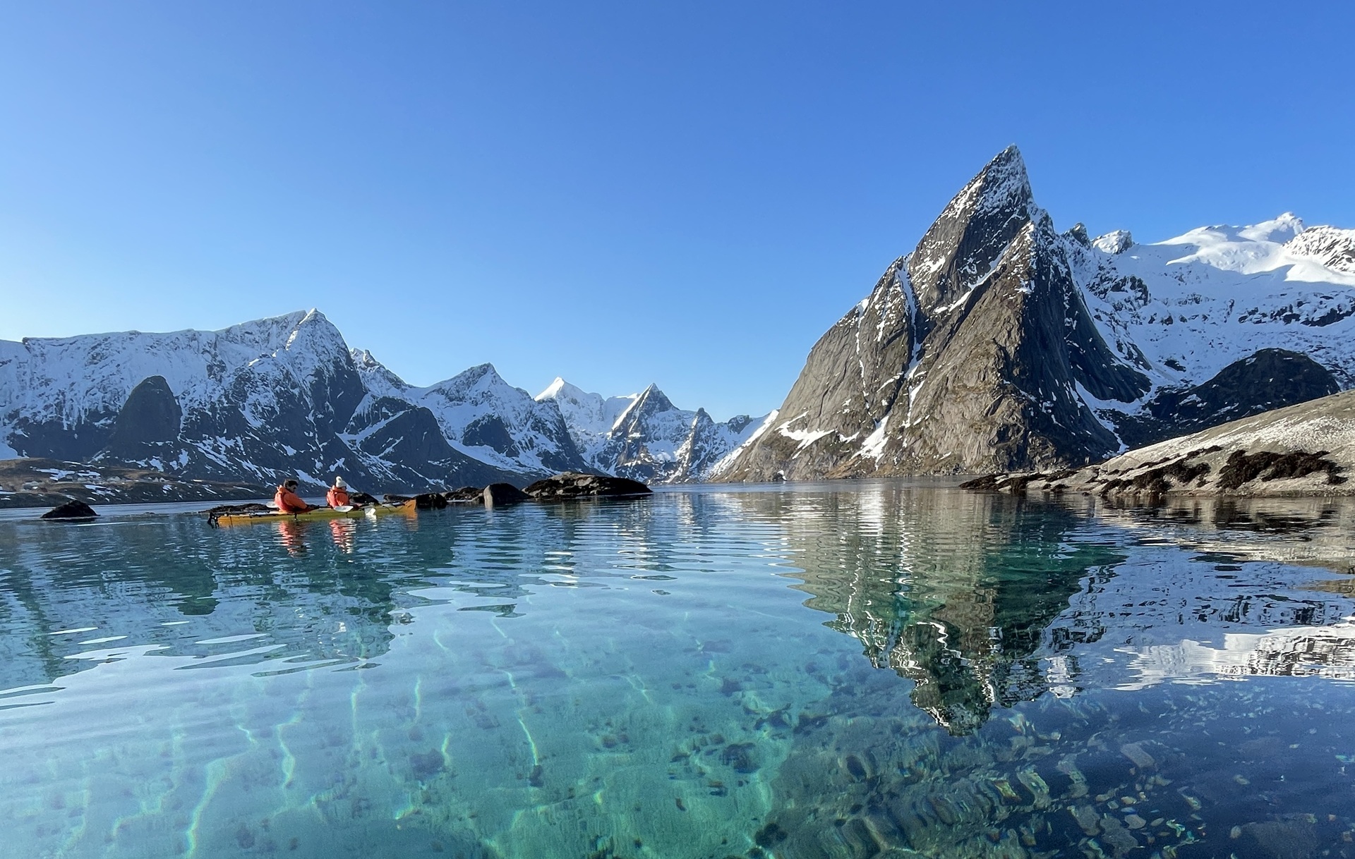 people-kayak-fjords-clear-turquoise-water-snow