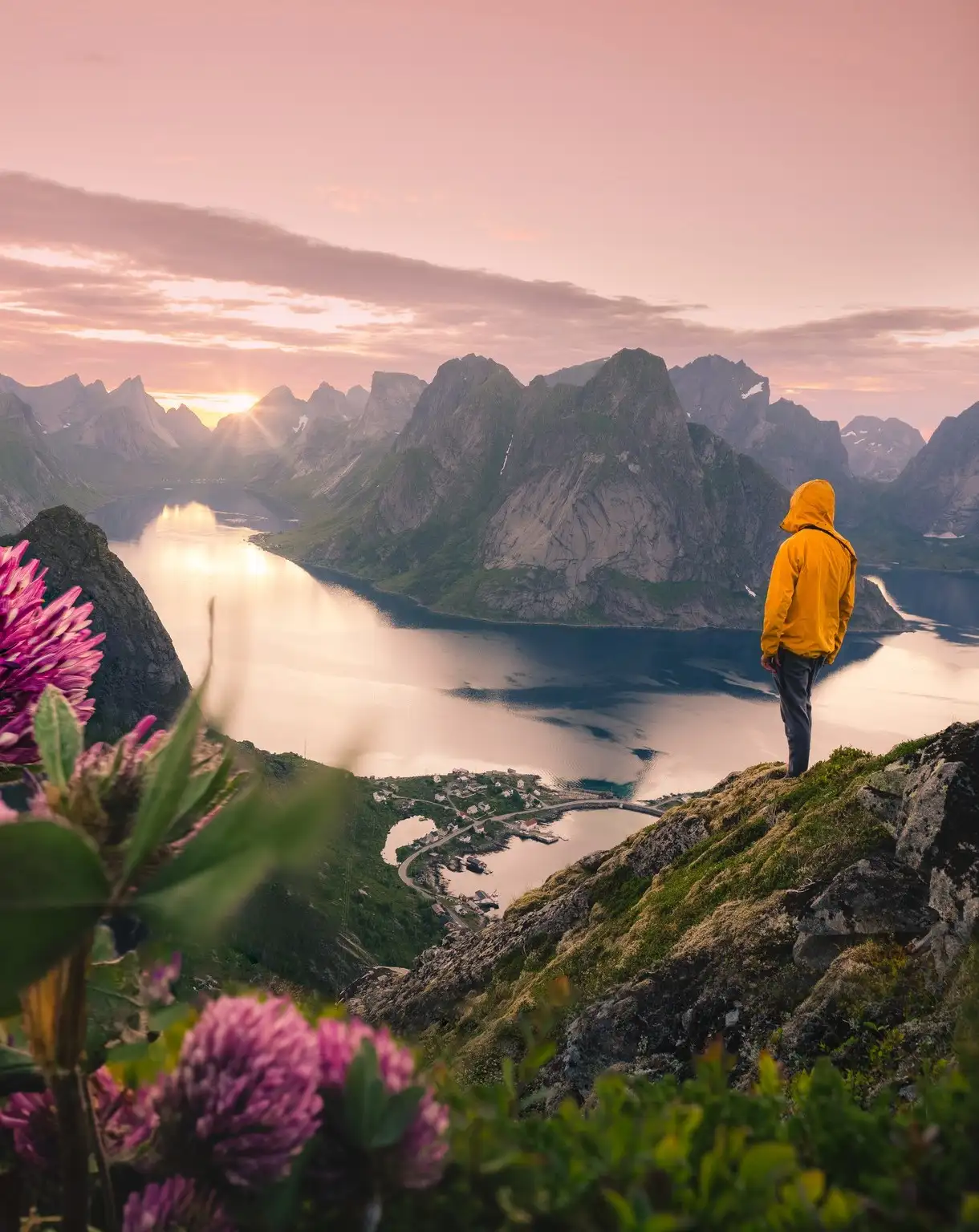 A hiker enjoying the view from Reinebringen in Reine, Lofoten Islands, Norway