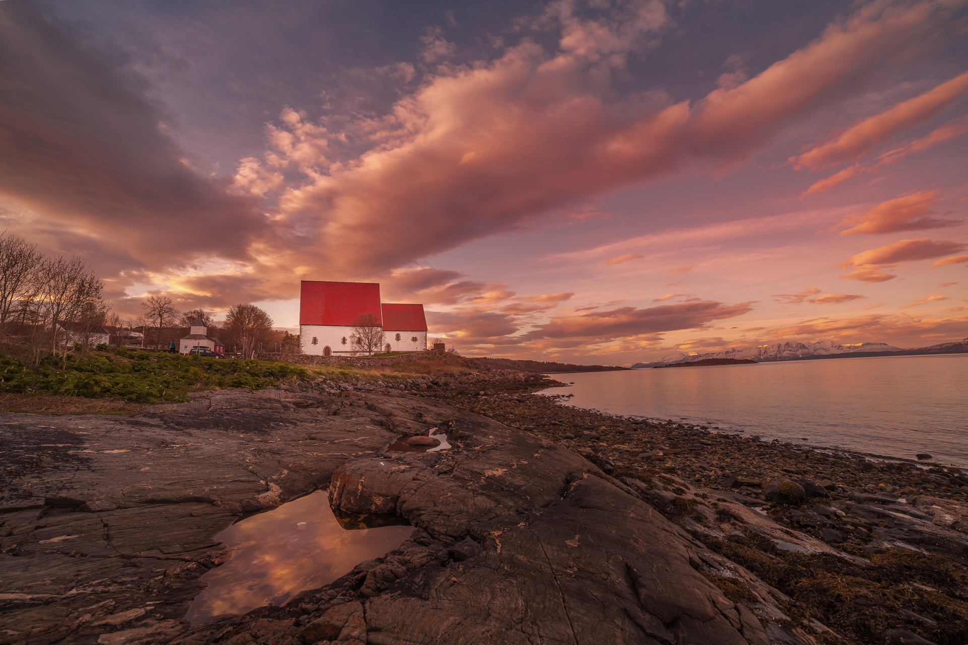 Ein Sonnenuntergang in Harstad, Norwegen, mit einem Küstenhaus im Hintergrund