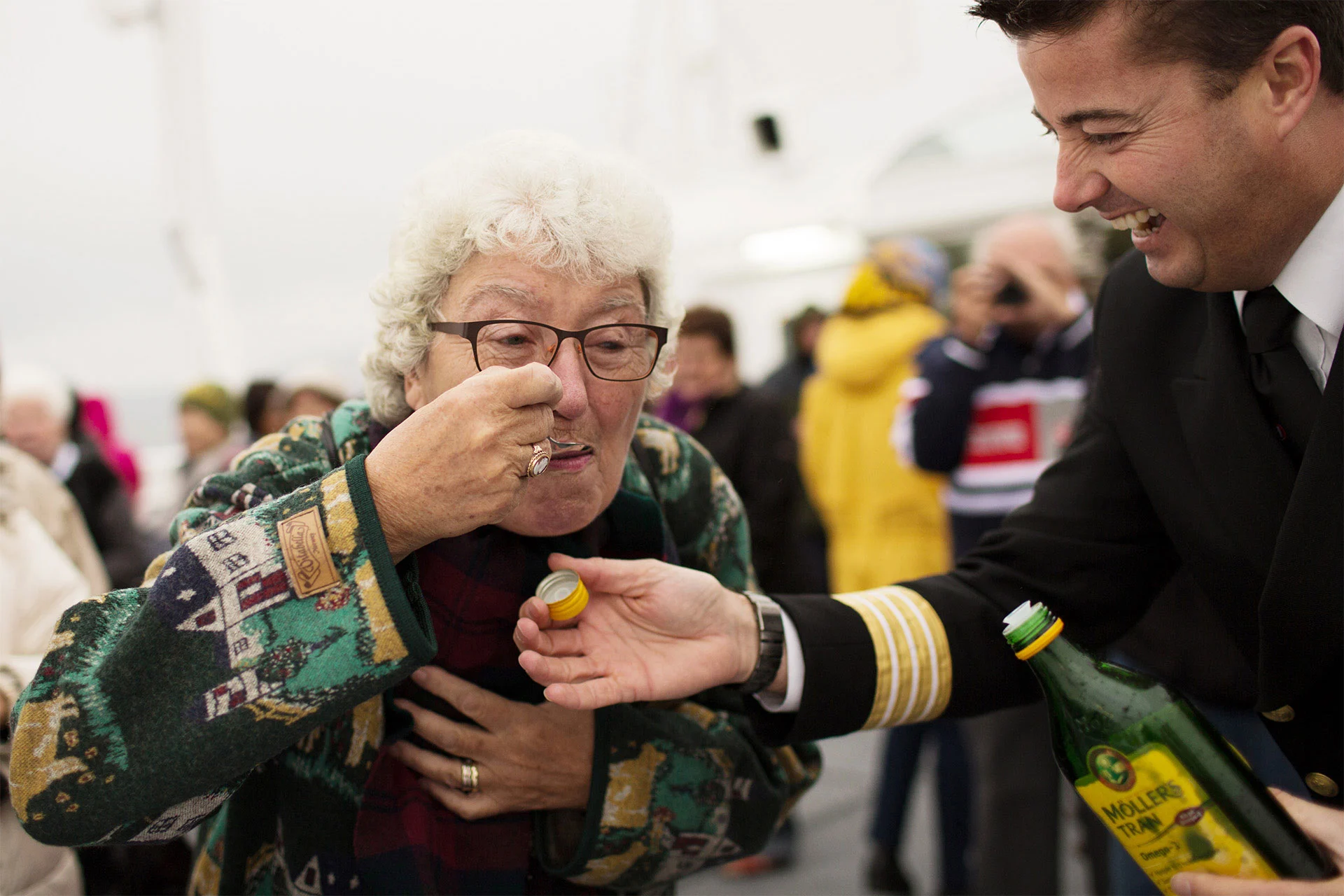 A woman tries a spoonful of cod liver oil on board a Hurtigruten ship while crossing the Arctic Circle